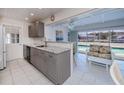 Well-lit kitchen showcasing stone countertops, tiled floors, modern appliances, and a serene pool view at 18451 Goodman Cir, Port Charlotte, FL 33948