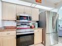 Well-lit kitchen featuring stainless steel appliances, light wood cabinets, and granite countertops at 18790 Countryman Ave, Port Charlotte, FL 33948