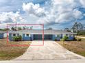 Charming duplex featuring a shared driveway, beautiful landscaping, and a classic design with a light-blue exterior at 1965 Louisiana Ave, Englewood, FL 34224