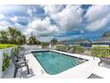 Inviting community pool area with comfortable lounge chairs, surrounded by a secure white fence at 1965 Louisiana Ave, Englewood, FL 34224