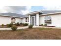 Close-up of the home's exterior with decorative metalwork above the front door and neatly trimmed bushes at 2125 Floribanna St, North Port, FL 34287