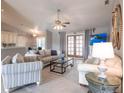 Bright living room with tile flooring, comfortable seating, and an open view to the kitchen and dining area at 2125 Floribanna St, North Port, FL 34287