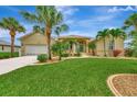 Charming single-story home with a well-maintained lawn and mature landscaping, including palm trees and flowering shrubs at 29 Tournament Rd, Rotonda West, FL 33947