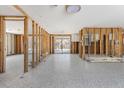 Spacious, unfinished interior with exposed wall framing, tile flooring, and bright natural light entering through large windows at 4065 N Beach Rd, Englewood, FL 34223
