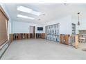Spacious living room with white walls, sky lights, and in need of repair from previous flooding at 4093 Pelican Shores Cir, Englewood, FL 34223