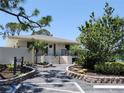 Clubhouse exterior with beautifully landscaped walkway and lush green foliage at 4260 Placida Rd # 21C, Englewood, FL 34224