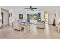 Comfortable living room featuring tile flooring, neutral decor, and a large window offering ample natural light at 5879 Venisota Rd, Venice, FL 34293