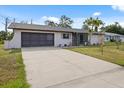 Charming single-story home with a spacious driveway and attached garage on a sunny day at 7180 Quarry St, Englewood, FL 34224