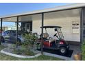 Carport view with a golf cart and a car parked under a covered area with support beams at 786 Heathercreek Ct, Englewood, FL 34223