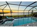 Screened in pool overlooking lake, perfect for relaxing evenings and enjoying beautiful sunset views at 8244 Shore Lake Dr, Englewood, FL 34224