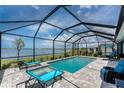 Inviting screened-in pool area with comfortable lounge chairs and scenic lake views at 8244 Shore Lake Dr, Englewood, FL 34224