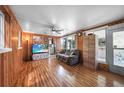 Inviting living room with wood paneled walls, hardwood floors, and a comfortable seating area at 857 Palmetto St, Englewood, FL 34223