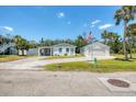 Quaint single story home with updated white exterior featuring a long driveway, covered car port and detached garage at 868 Harvard St, Englewood, FL 34223