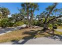 Long, curving driveway surrounded by mature trees and lush landscaping leading to a private residence at 9144 Spring Valley Rd, Englewood, FL 34224