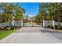 View of the entrance gate to a private community, featuring decorative pillars and a manicured lawn at 9144 Spring Valley Rd, Englewood, FL 34224