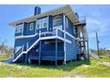 Charming coastal home featuring durable blue siding, multiple elevated decks, and convenient stairs at 9594 Doubloon Trl, Placida, FL 33946