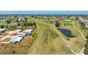 Aerial view of a single-story home situated on a golf course with mature trees and landscaping at 11 Oakland Hills Rd, Rotonda West, FL 33947