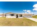 Charming single-story home with a well-manicured lawn, attached two-car garage, and covered front entryway at 11 Oakland Hills Rd, Rotonda West, FL 33947