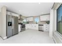 Bright kitchen with stainless steel appliances, white cabinetry, and a view of the outdoors at 11 Oakland Hills Rd, Rotonda West, FL 33947