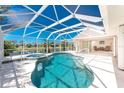 Screened-in pool and hot tub with clear blue water and canal views at 1157 Rotonda Cir, Rotonda West, FL 33947