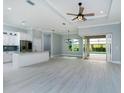 Open concept living space featuring tile flooring, and sliding glass doors leading to a screened-in pool area at 13344 Gershwin Ln, Port Charlotte, FL 33981