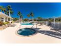 Community pool and hot tub surrounded by lounge chairs and manicured landscaping at 13392 Abercrombie Dr, Englewood, FL 34223
