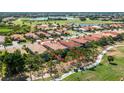 Aerial view of home showcasing beautiful landscaping, golf course, and lake views at 142 Savona Way, North Venice, FL 34275