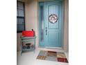 Inviting front entrance with a decorative wreath, stylish rug, and a bright-colored mailbox at 142 Yellow Pine Dr, Rotonda West, FL 33947