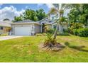 Well-maintained single-story home featuring a two-car garage and tropical landscaping at 143 Crevalle Rd, Rotonda West, FL 33947