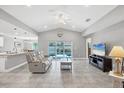 Spacious living room features tile floors, neutral walls, fan, with a sliding glass door that leads to the pool at 149 Garland Way, Rotonda West, FL 33947