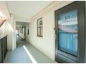 Hallway with unit 212 featuring a screened door, white walls, and a view of the building's architecture at 1551 Beach Rd # 212, Englewood, FL 34223
