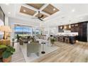 Open-concept living room with modern decor, wood-look flooring, and a seamless transition to the kitchen at 15850 Viscount Cir, Port Charlotte, FL 33981
