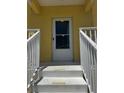 Front door with storm door and freshly painted white stairs and railings at 169 Boundary Blvd # 169P, Rotonda West, FL 33947