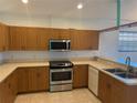 Kitchen featuring wooden cabinets, stainless steel appliances, and tile flooring at 169 Boundary Blvd # 169P, Rotonda West, FL 33947