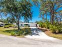 Charming single-story home boasts lush landscaping, a long driveway, and inviting curb appeal on a sunny day at 1691 Lakeview Pl, Englewood, FL 34223