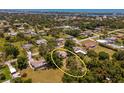 Aerial view of a home in a lush neighborhood with surrounding trees and other residential properties at 1712 Fessler St, Englewood, FL 34223