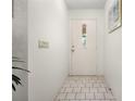 Bright entryway featuring neutral tile flooring and a white door, creating a clean and welcoming space at 1712 Fessler St, Englewood, FL 34223