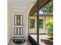 Inviting front entryway with a decorative door, complemented by an arched entryway and tasteful landscaping at 1712 Fessler St, Englewood, FL 34223