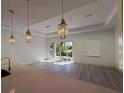 Open-concept living space with stylish lighting and sliding glass doors at 18043 Hillsborough Blvd, Port Charlotte, FL 33954