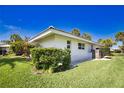 Side view of home with manicured green lawn and tidy landscaping and shrubs at 19 Oakwood Dr N # 19, Englewood, FL 34223