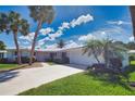 Charming single-story home with a well-maintained lawn, mature palms, and a pristine white tile roof at 19 Oakwood Dr N # 19, Englewood, FL 34223