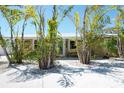 Inviting front entrance landscaped with mature palms, providing shade and tropical charm at 2060 Oyster Creek Dr, Englewood, FL 34224