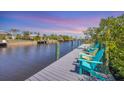 Relax on the waterfront dock with colorful Adirondack chairs and tranquil water views at 2441 Vance Ter, Port Charlotte, FL 33981