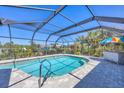 Enjoy this screened-in pool with ample seating and a colorful umbrella for sunny days at 2441 Vance Ter, Port Charlotte, FL 33981