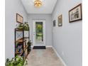 Welcoming entryway with neutral tile flooring, decor, and natural light streaming through the front door at 2678 Alva St, North Port, FL 34291