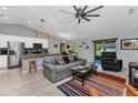 Open-concept living room featuring a vaulted ceiling, tile flooring, and seamless flow into the kitchen at 2678 Alva St, North Port, FL 34291