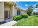 A welcoming home exterior with well-kept lawn, lush landscaping, and a view of the pond at 2692 Wax Myrtle Ct, Port Charlotte, FL 33953
