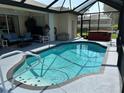 Enjoy this screened-in pool area with hot tub, ceiling fan, and ample room for entertaining and relaxing at 2864 Traverse Ave, North Port, FL 34286