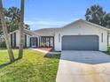 Well-maintained one story home with a driveway leading to an attached garage and a welcoming entrance at 4210 Day St, Port Charlotte, FL 33948