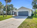 One-story home with an attached garage, lush green lawn, and a paved driveway, perfect for suburban living at 4210 Day St, Port Charlotte, FL 33948
